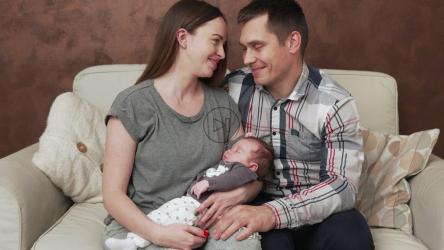 年轻夫妇坐在沙发上和他们的孩子[]