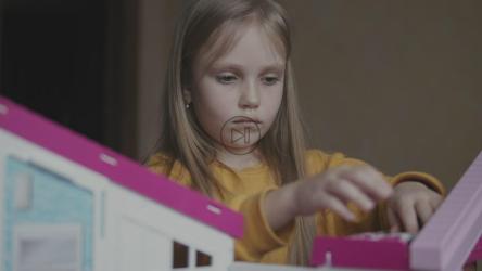 小女孩在玩具屋里玩她的娃娃[]