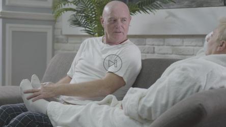 一对老夫妇在沙发上放松，享受足部按摩[]