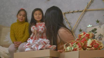 母亲和女儿们在圣诞节打开礼物[免费商用]