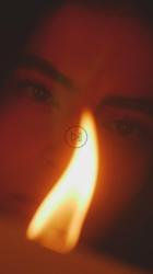 欣赏蜡烛火焰的年轻女子的脸[免费商用竖屏]