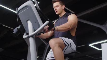 健身自行车上戴耳机的健康人[]