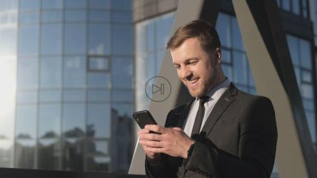 快乐的商人拿着他的智能手机[]