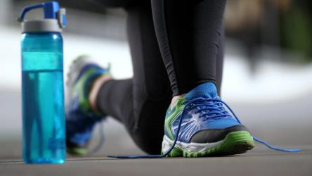 Person in sportswear tying his shoelaces[]