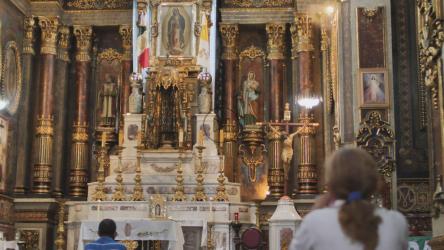 在教堂内的一个大祭坛前祈祷的女士[免费商用]