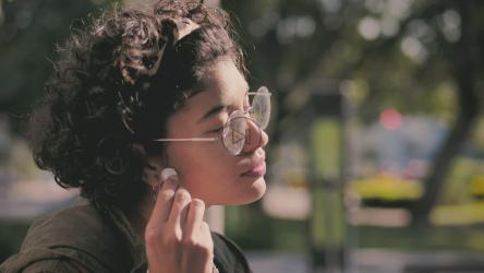 Teenager putting on headphones in the park[免费商用]