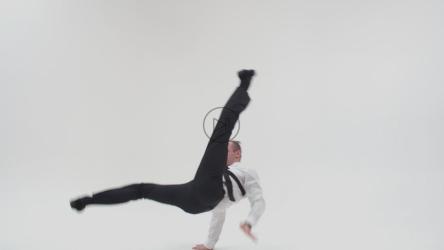 Man in a suit breakdances against a white background[]