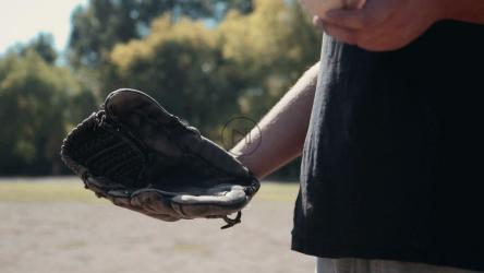 棒球运动员把球扔到手套里[]