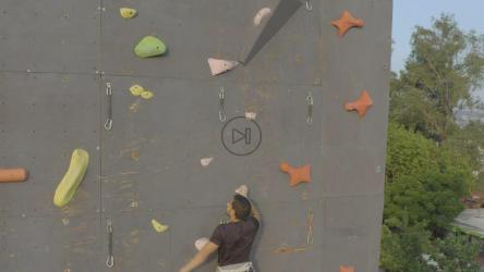 一位年轻的登山家正在攀登一堵用于登山的高墙[免费商用]