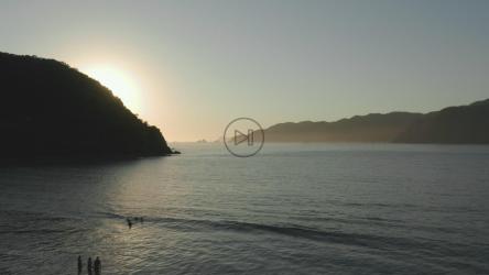 日落时飞越一个小海湾的大海[4K免费商用]