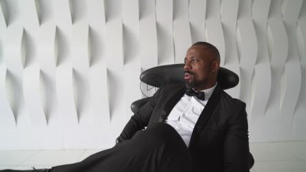 打着领结的男人懒洋洋地躺在皮椅上[]