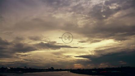 Sky with clouds above the river of a city[]