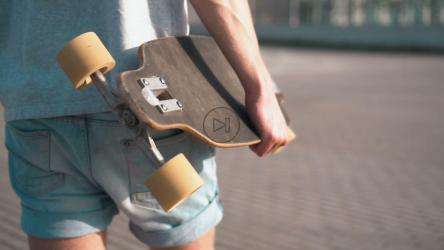 滑板手拿着滑板行走[]