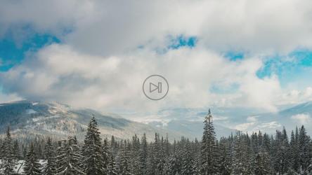 云朵在白雪皑皑的树木繁茂的景观上移动[4K]