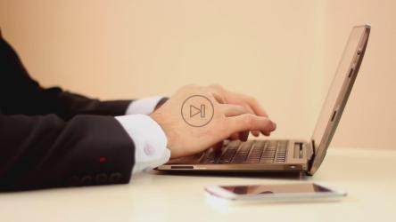 一个穿着西装的男人在电脑上工作的手[]