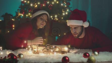 一对夫妇在圣诞节玩玩具火车[]