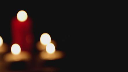 Candles burning in the dark, out of focus shot[]