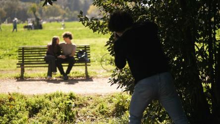 隐藏在树后的摄影师看着一对夫妇[]