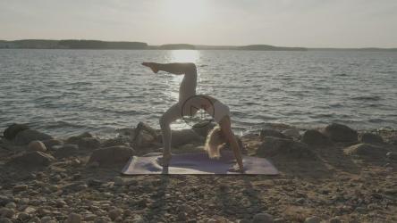 Young woman doing yoga at a sunset on a beach[]
