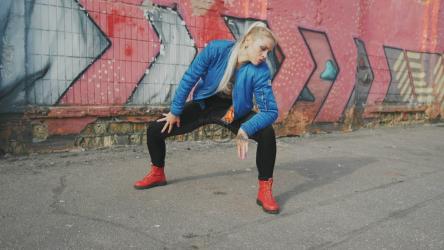 Blonde girl dancing in an empty street[]