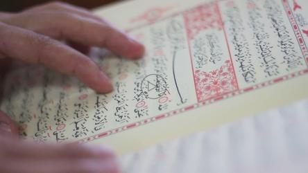 一个人阅读《古兰经》的特写[]