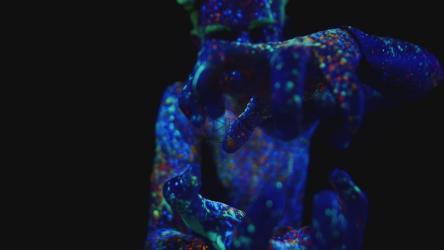 模特在紫外线下用荧光漆做手势[]