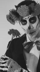 一个男人化着骷髅妆，嘴里叼着一朵金盏花[免费商用竖屏]