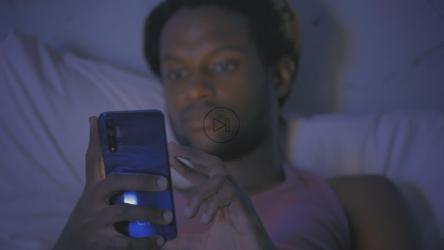 Young man lying on his bed checking his smartphone[免费商用]