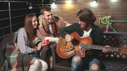 男人在放松的夜晚为朋友弹吉他[4K]