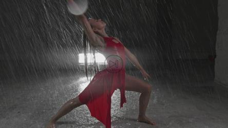 年轻的红衣女子在雨中跳舞[]