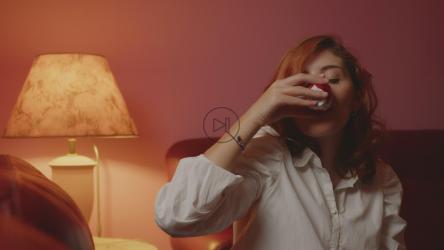Girl enjoying a cup of coffee in her living room[]
