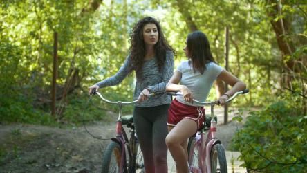 两名妇女骑自行车穿过森林[]