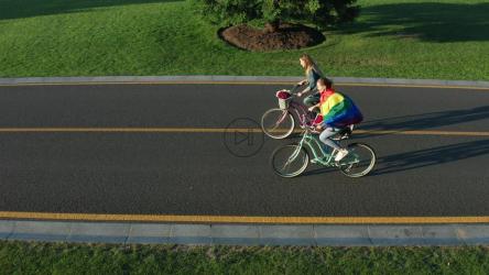 一对夫妇骑着自行车走在一条空荡荡的路上[]