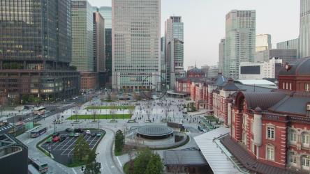 人们和汽车在一个大建筑的城市里移动[]