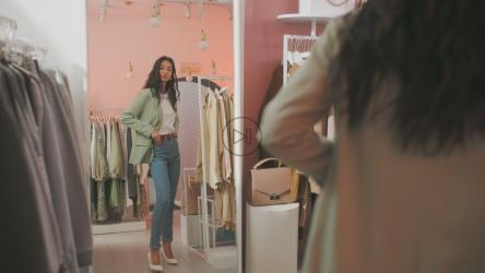 年轻女子在商店里试衣服[]