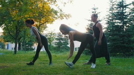 三个女人在公园的草地上锻炼[]