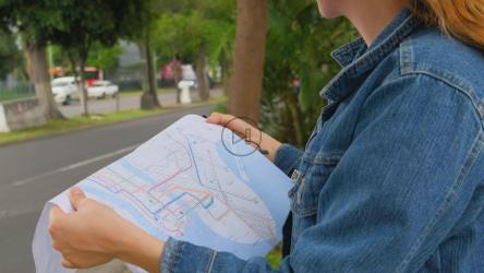 街上的女人拿着城市地图定位自己[免费商用]