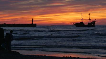 日落在海滩上与人和大海中的船[4K]