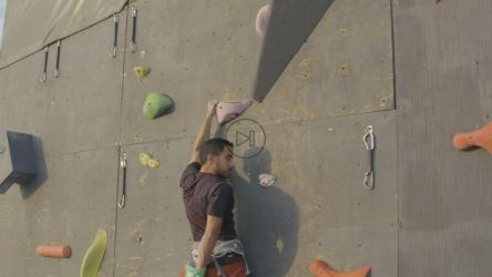 熟练地爬上一堵巨大的登山墙的顶部[免费商用]