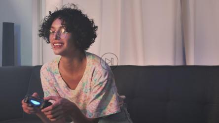 年轻女子在沙发上玩电子游戏[免费商用]