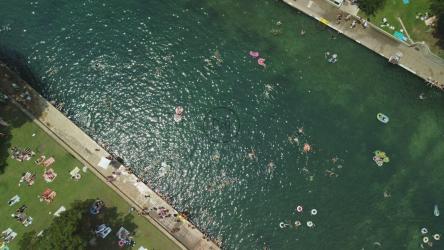 阳光明媚的河流鸟瞰图，有很多人[4K免费商用]