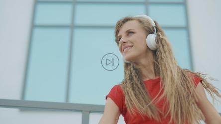 户外戴耳机的年轻女子[]