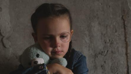 孤独的小难民女孩拥抱她的泰迪熊[]