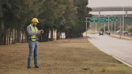 戴安全帽的男子在路边驾驶无人机[免费商用]