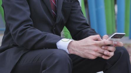 Man in a suit and a mask checks his cell phone[4K免费商用]