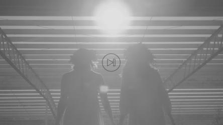 Women holding hands walking in the sun under an industrial roof[免费商用]