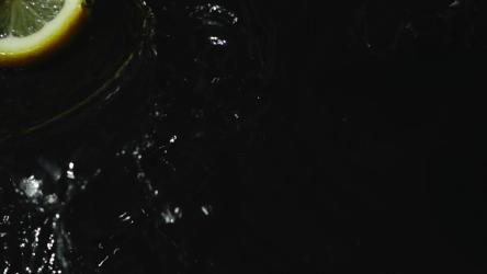 柠檬片落入深色水中[]