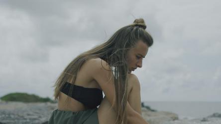 忧郁忧郁的女孩在一个阴天的海滩[]