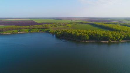 River near a growing area, aerial shot[4K]