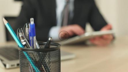 一名穿着西装拿着平板电脑工作的男子[]